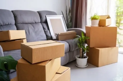 Moving boxes stacked beside a sofa, ready for pickup